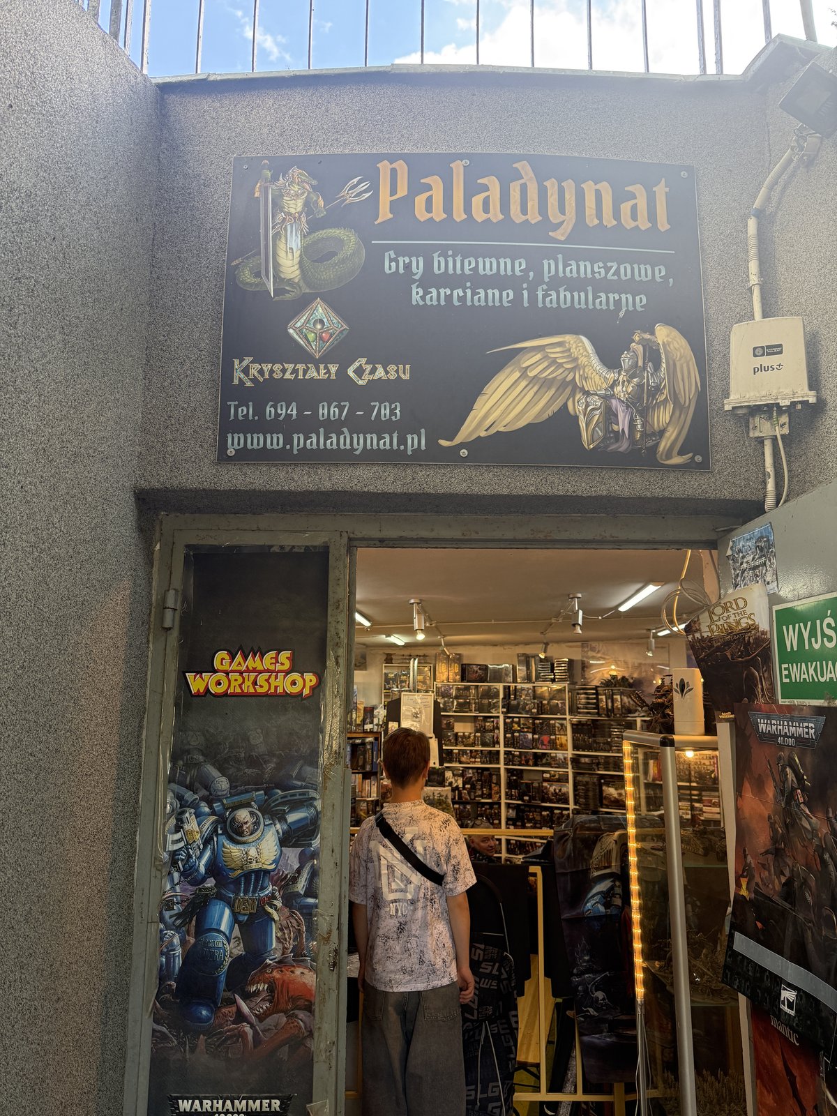Wejście do sklepu Paladynat z szyldem Kryształy Czasu i logo Games Workshop